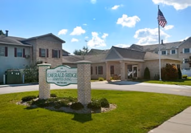 Exterior view of Emerald Ridge of Neenah with entrance, sign, and flag.