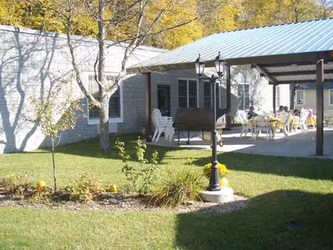 Senior living facility exterior with covered patio and outdoor seating area.