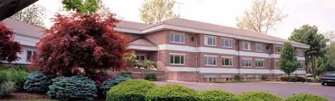 Exterior view of Central Village Independent living facility with brick facade and landscaped grounds.