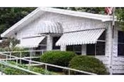 White Baker-Katz Nursing Home exterior with awning-covered windows and trimmed hedges.
