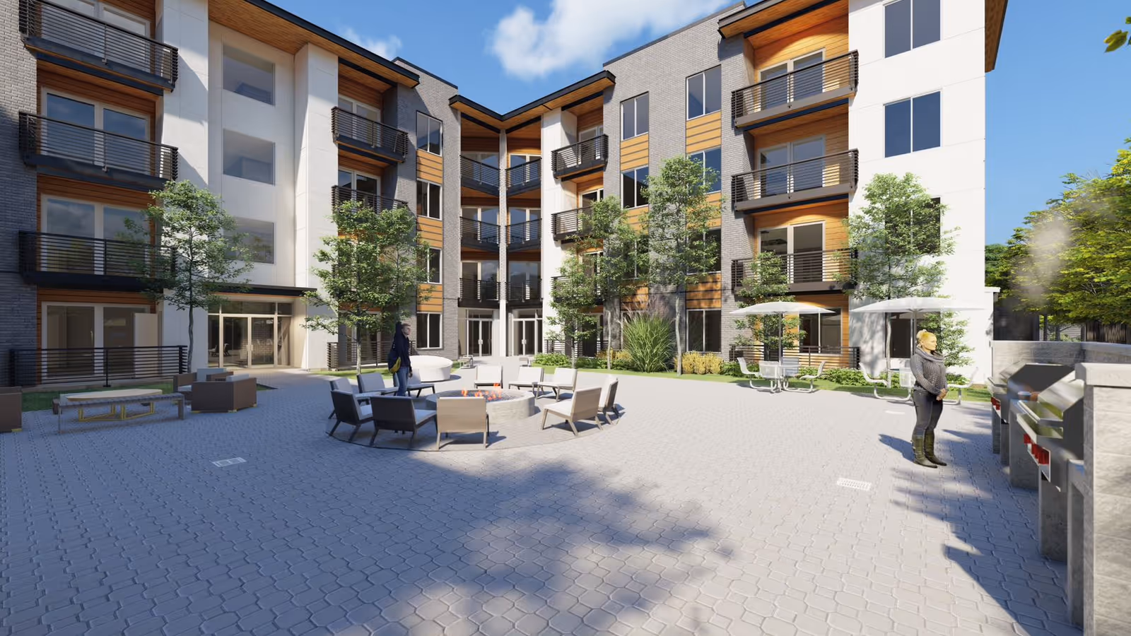 Open paved courtyard of a modern multi-story senior living building with seating, trees, balconies and a couple of people.