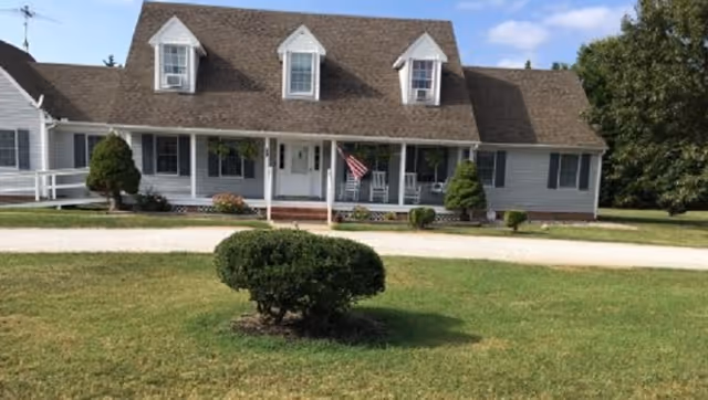 Front view of Rayland Acres Assisted Living building with porch and lawn.