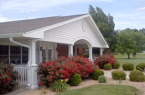 Exterior view of Mount Hope Nursing Center with a covered porch and neatly trimmed landscaping.