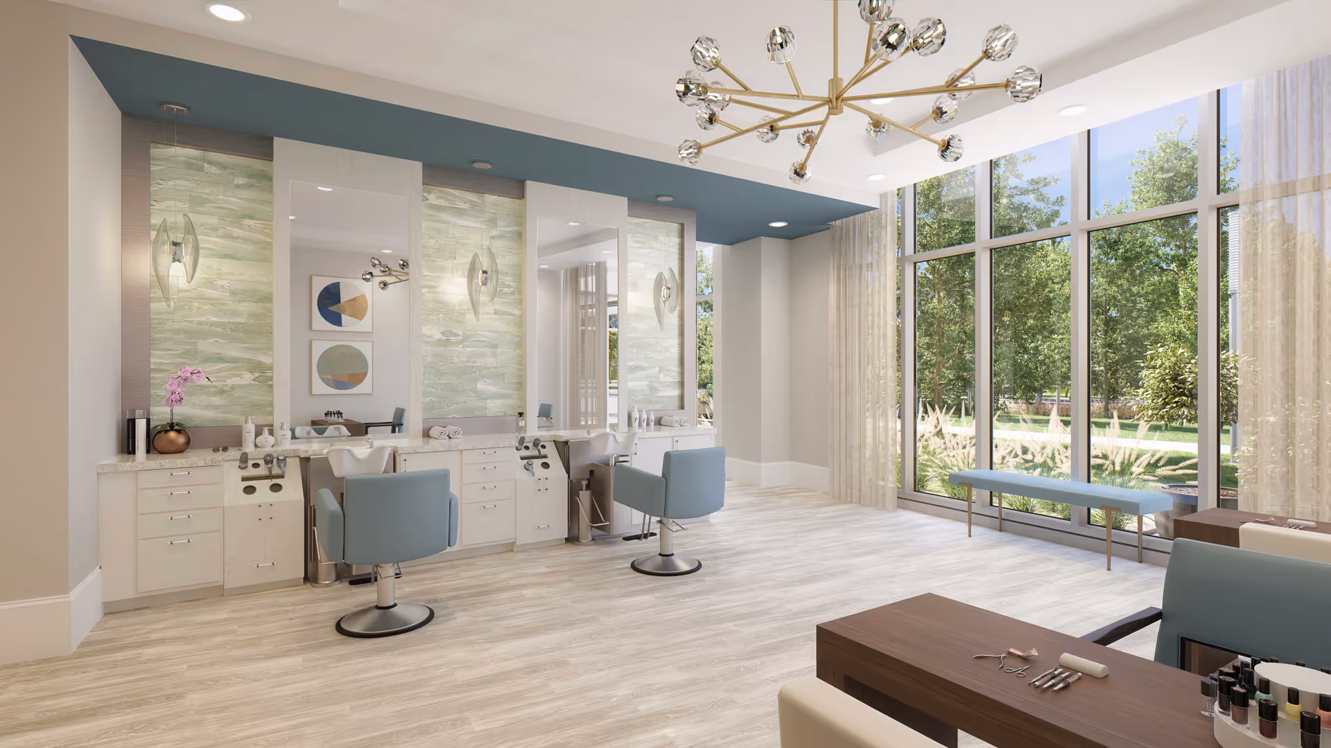 A bright and modern salon area with two styling chairs in front of large mirrors mounted on a wall with green textured panels. The room has light wood flooring, a large window with sheer curtains letting in natural light, and a blue bench by the window. A contemporary chandelier hangs from the ceiling, and a table with manicure tools and nail polish is visible in the foreground.