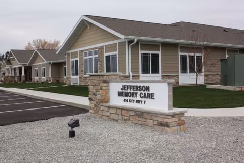Exterior view of Jefferson Memory Care facility with a stone sign.