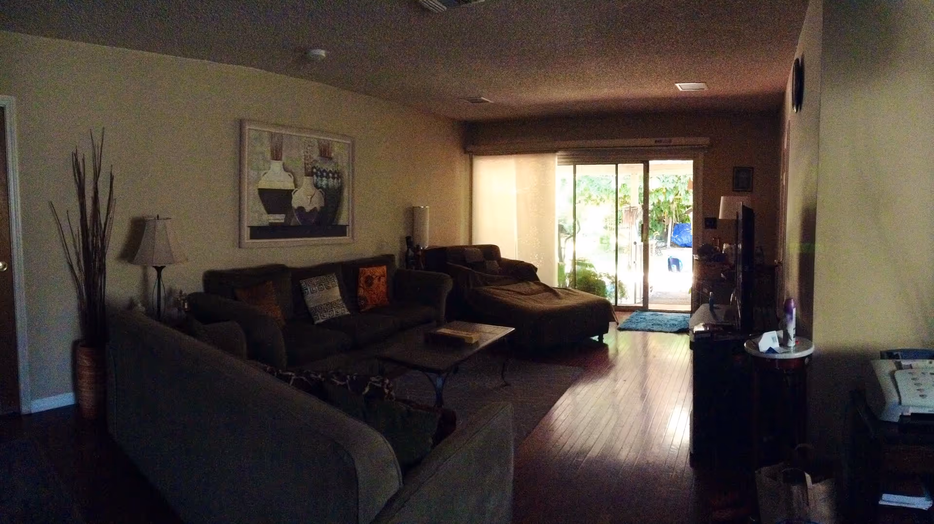Living room with upholstered sofas, a coffee table, and a sliding glass door to a patio.