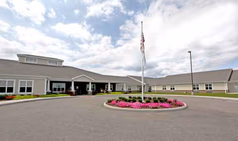 Front view of The Laurels of Steubenville with circular driveway, flagpole, and landscaped flower bed.