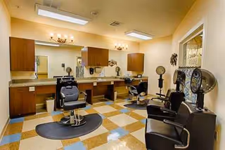 A senior living facility hair salon with styling chairs, mirrors, and counter stations.