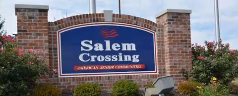 Brick sign entrance for Salem Crossing senior living facility, with landscaping in front.