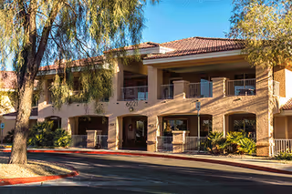Exterior view of Marquis Care Plaza Regency, a tan two-story building with arches.