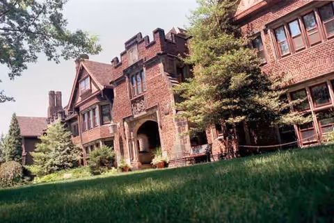 Exterior view of Judson Park, a senior living building, with arched entrance and lawn.