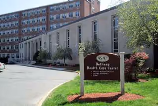 Exterior view of Bethany Health Care Center with sign and adjacent driveway.