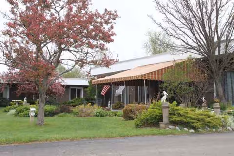 Exterior view of the Dunkirk Rehabilitation and Nursing Center with striped awning and landscaped entrance.