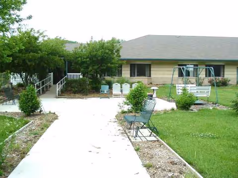 Outdoor area of Blue Valley Lutheran Care Home with walkway, benches, and green lawn.