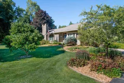 Single-story senior living facility with a well-kept lawn and trees in front.