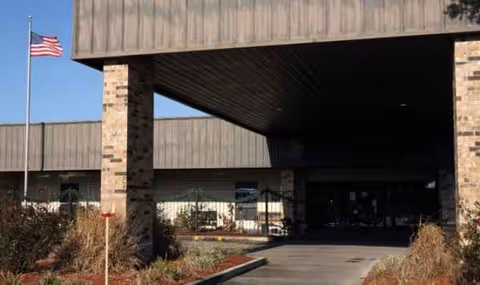 Exterior view of Patterson Healthcare Center entrance with brick pillars and an American flag.