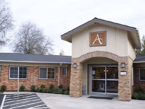 Exterior entrance of Avamere Rehabilitation of Beaverton with brick arch and glass doors.