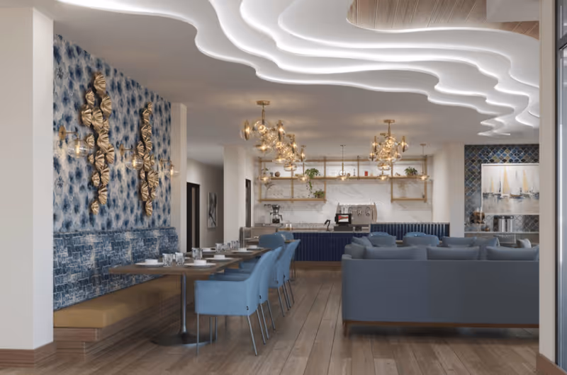 Stylish communal dining and lounge area with blue chairs, banquette seating, sofas, and a decorative illuminated ceiling.