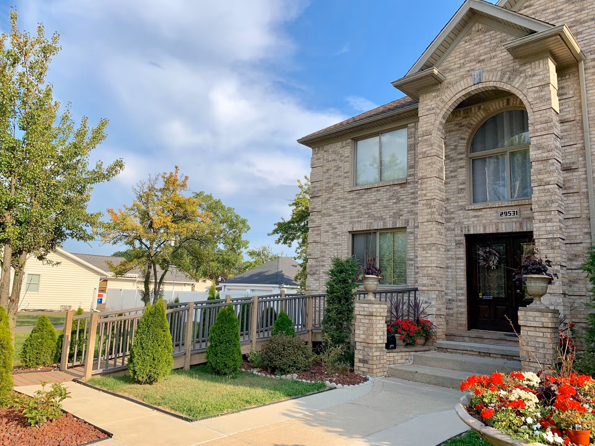 Front exterior of Blessed Assisted Living, a brick facility with an arched window and landscaped entrance.