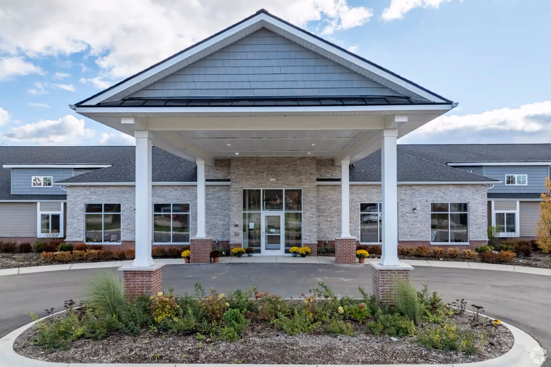 Front view of Hampton Manor of Van Buren with a covered entry and landscaped approach.