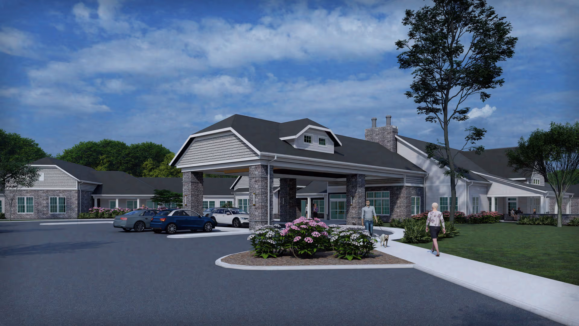 Exterior view of Quincy Place Senior Living facility showing a large covered entrance with stone pillars, several parked cars, landscaped flower beds, a sidewalk, and two people walking, one with a dog. The building has a gray roof and white siding with multiple windows under a partly cloudy sky.