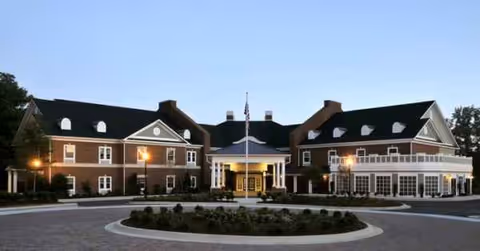 Exterior view of Arbor Terrace Crabapple building with a circular driveway and entrance.