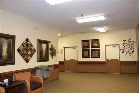 Interior hallway at Aspire of Excelsior Springs, with seating, artwork, and closed doors.