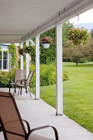Lafayette Center outdoor porch with chairs, hanging baskets, and a grassy lawn.