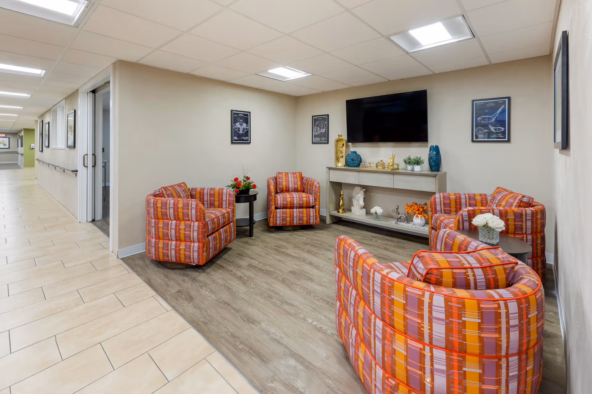 Colorful circular chairs encircle a lounge with a wall-mounted TV.