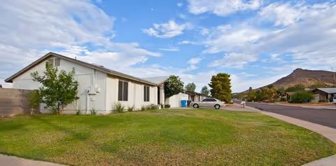 Exterior view of Desert Comfort Assisted Living Home, a single-story facility with lawn and street.