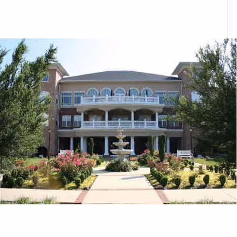 Front view of Parc at Duluth, GA senior living building with fountain and landscaped garden.