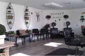 Bright Westlake Mews lounge with chairs, tables, plants, and wall art.
