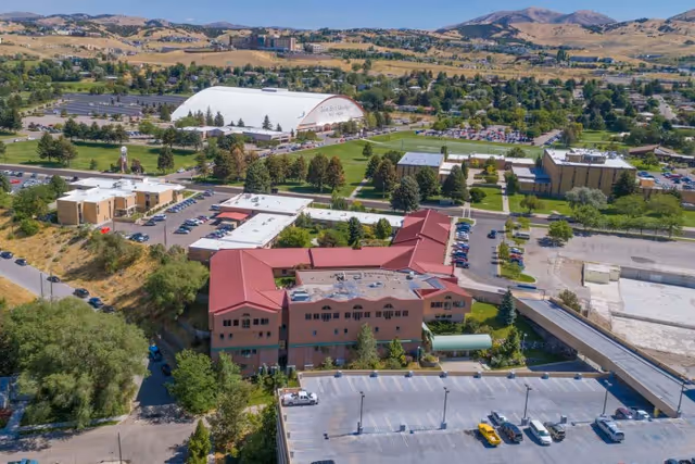Aerial view of Gateway Transitional Care Center complex with surrounding parking lots, nearby buildings, and distant hills.