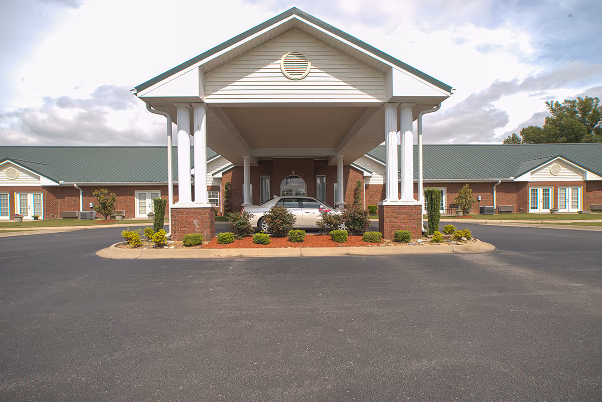 Front view of The Bungalows at Jonesboro facility with a covered entrance and driveway.