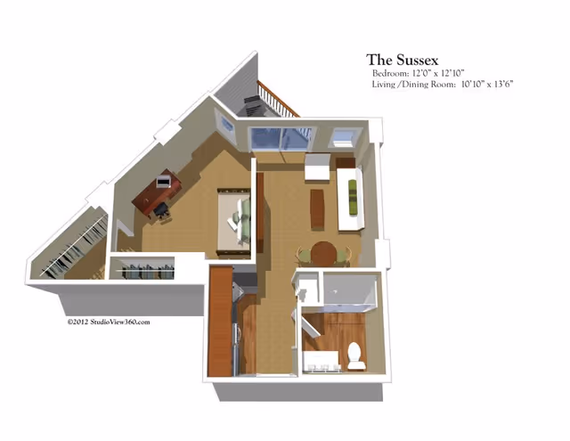 3D floor plan of The Sussex apartment featuring a bedroom with a bed and desk, a living/dining room with a sofa, coffee table, and dining table with chairs, a kitchen area, and a bathroom with a toilet and shower. The layout includes a balcony accessible from the living room.