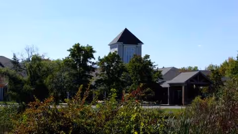 Exterior view of Kendal at Oberlin with a towered building front and trees.