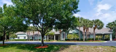 Brookdale Stuart senior living facility exterior with a tree-lined entrance and walkway.