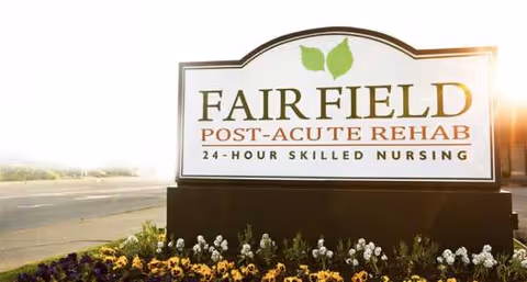 Exterior sign for Fairfield Post-Acute Rehab with flower bed near road