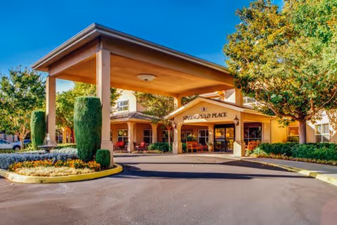 Front view of Springfield Place senior living facility entrance under a porte-cochere.