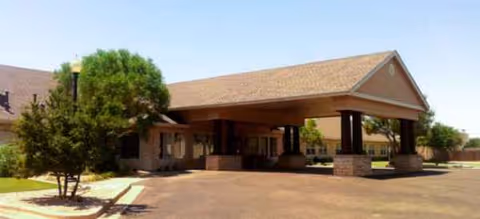 Exterior view of Brookdale Monterey entrance with a covered driveway and brick pillars.