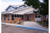 Exterior view of Napoleon Care Center entrance with brick facade and ramp.