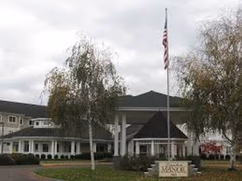 Exterior view of Vineyard Park of Lynden Manor entrance with flag and trees.