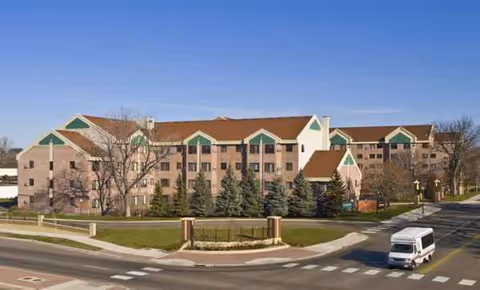 Exterior view of Copperfield Hill senior living facility with trees and a roundabout.