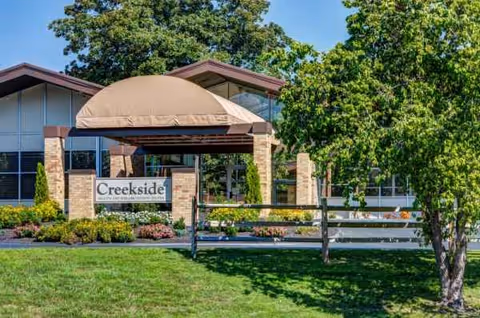 Exterior view of Creekside Center for Rehabilitation & Healing with entrance canopy and sign.