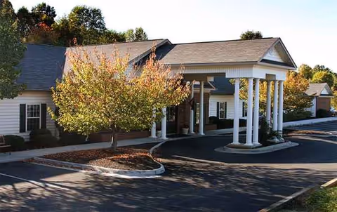 Front view of Heritage Green Assisted Living building with covered entrance and circular driveway.