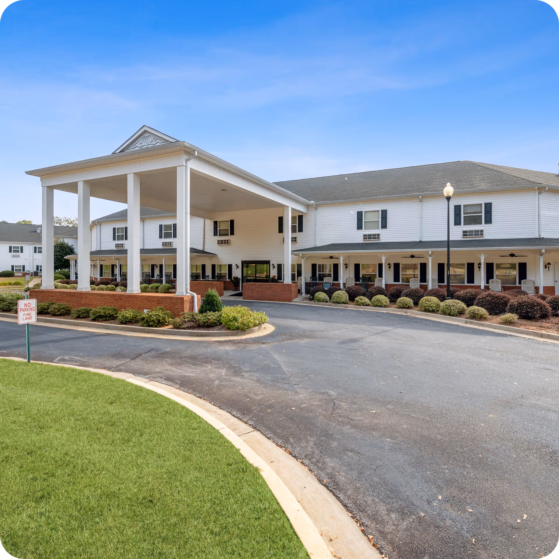 Exterior view of Highlands Senior Living with a large covered entrance and landscaped driveway.
