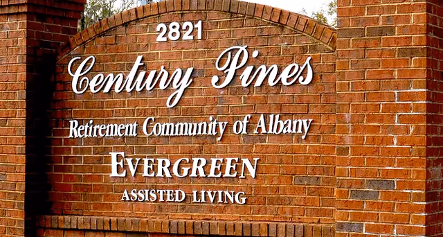Brick sign at the entrance of Century Pines Retirement Community of Albany, displaying the address 2821 and indicating it is an Evergreen Assisted Living facility.