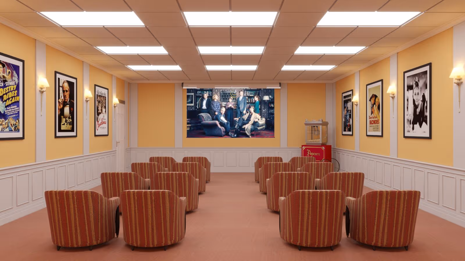 A small movie theater room with rows of red and orange striped armchairs facing a large screen displaying a movie scene. The walls are painted yellow with white wainscoting and decorated with framed classic movie posters. There is a popcorn machine in the back right corner of the room.