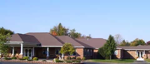 Single-story brick assisted living facility with a covered entrance and manicured lawn.