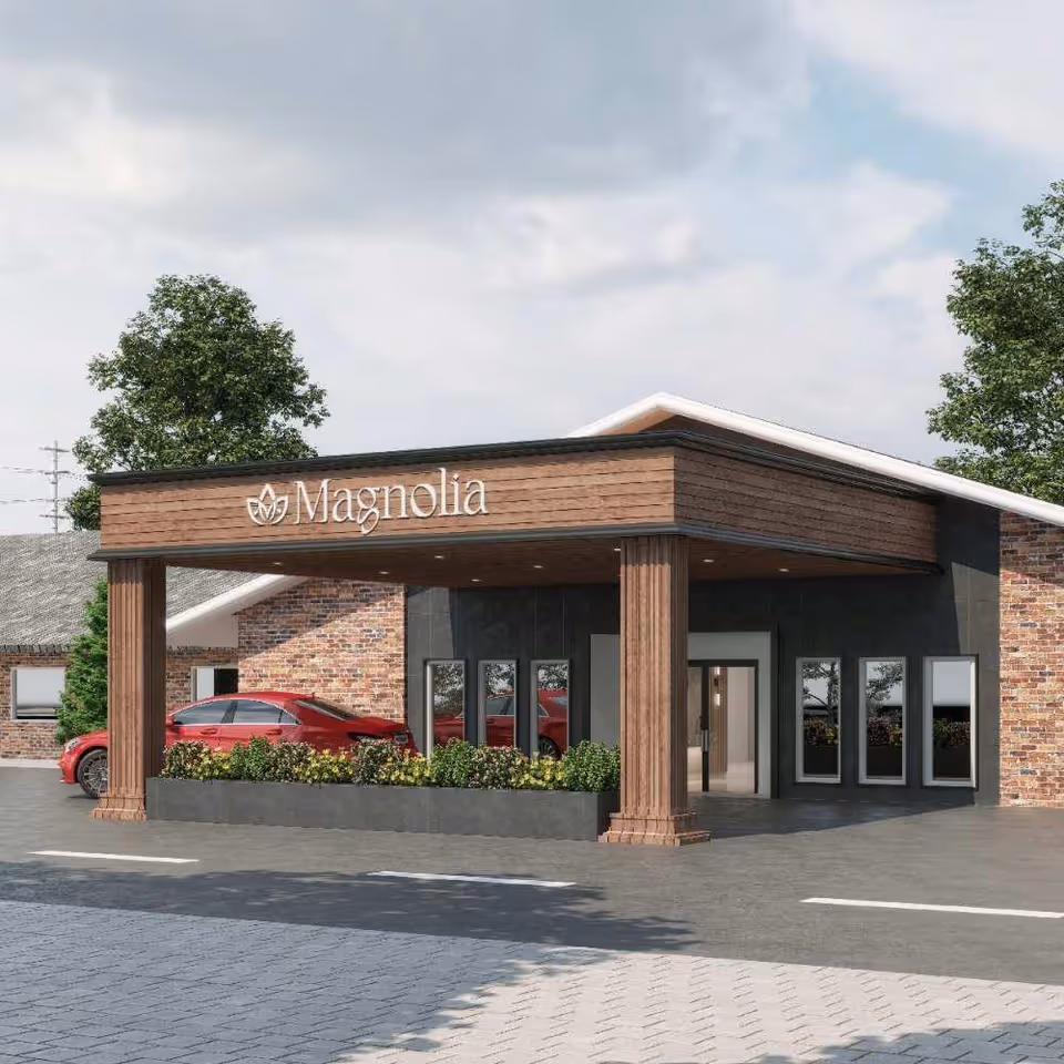 Front entrance of Magnolia with a covered porte-cochère, planters and a parked red car.